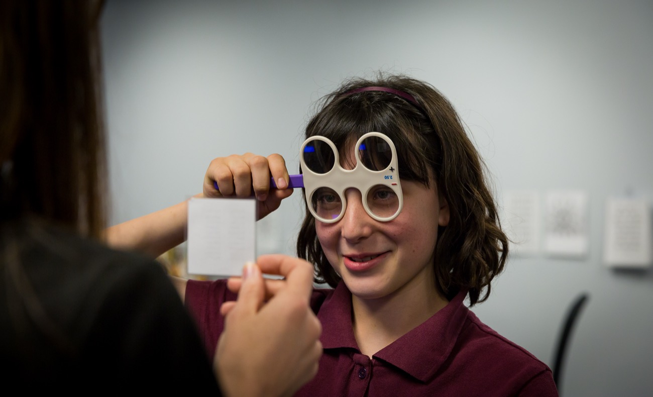 A Walesby vision therapist guiding a young patient through a lens exercise