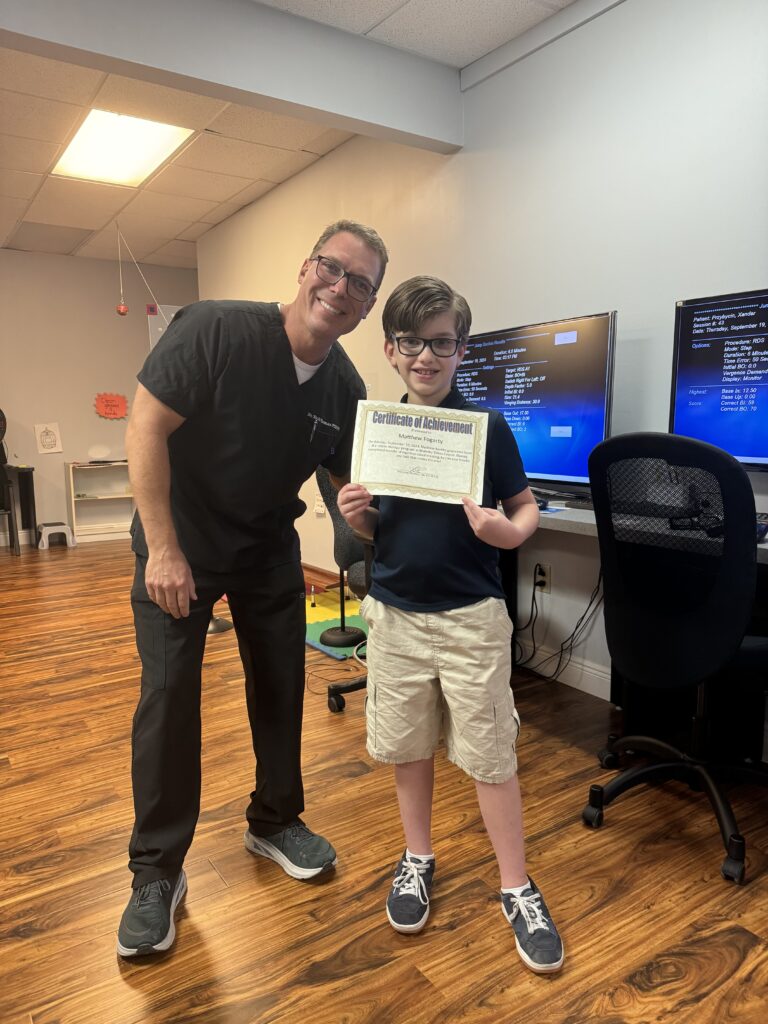 Matthew with his certificate after ten phases of vision therapy